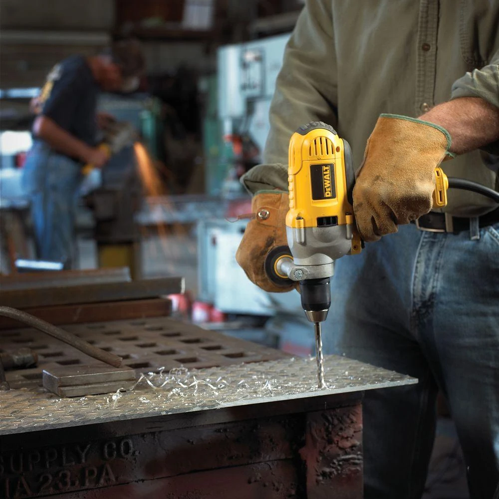 A worker using a DEWALT drill on a steel workpiece