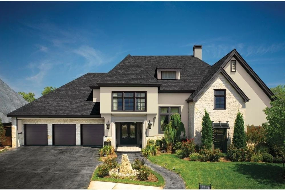 Charcoal shingle roof on a light stone house