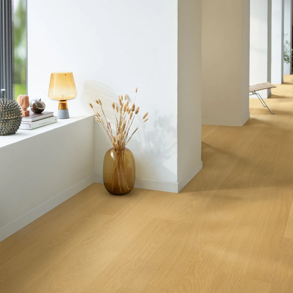 Warm oak-look flooring through a sunlit room with a low window seat