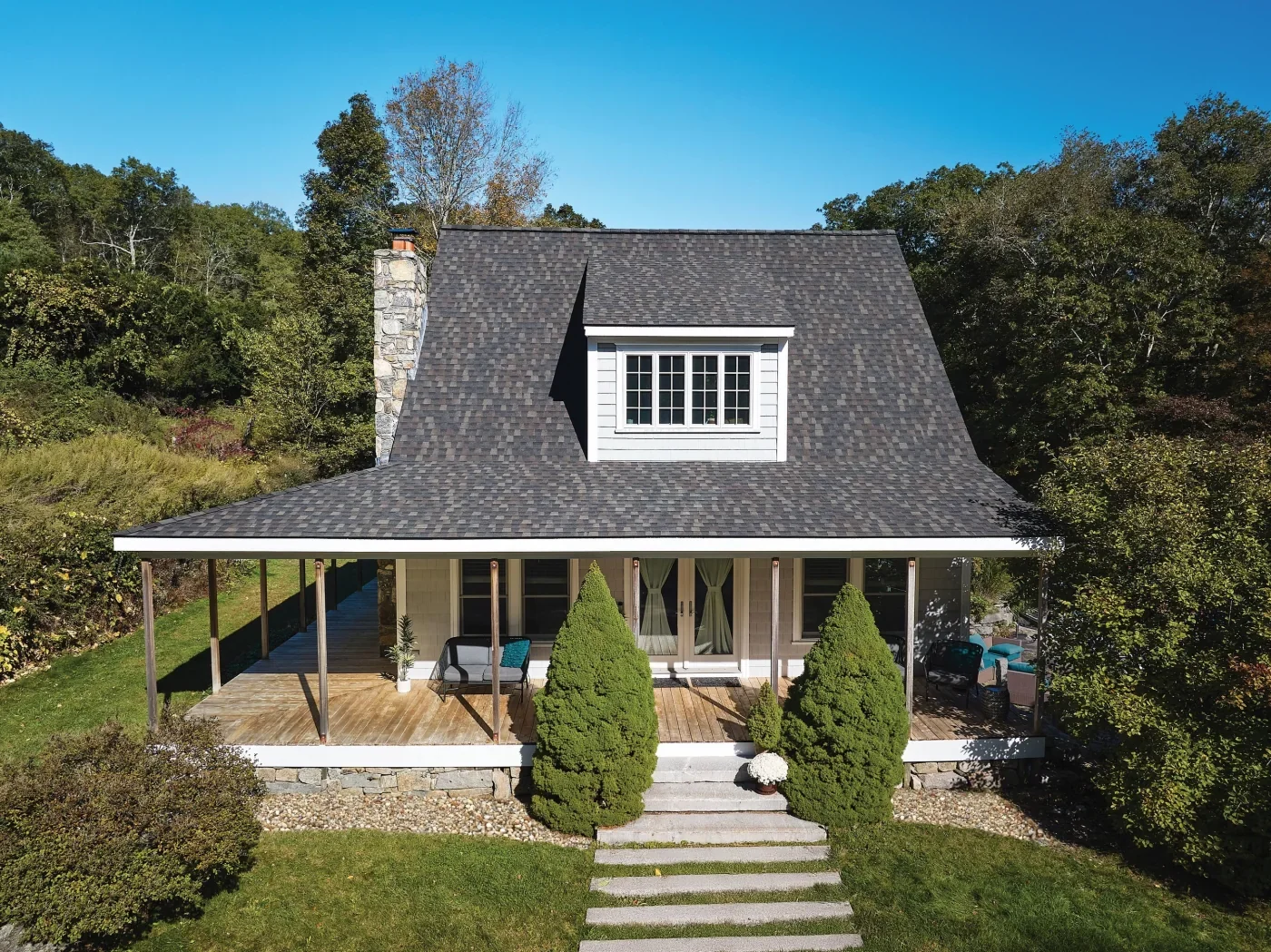 Dark architectural shingles across the roof of a stone-and-clapboard house